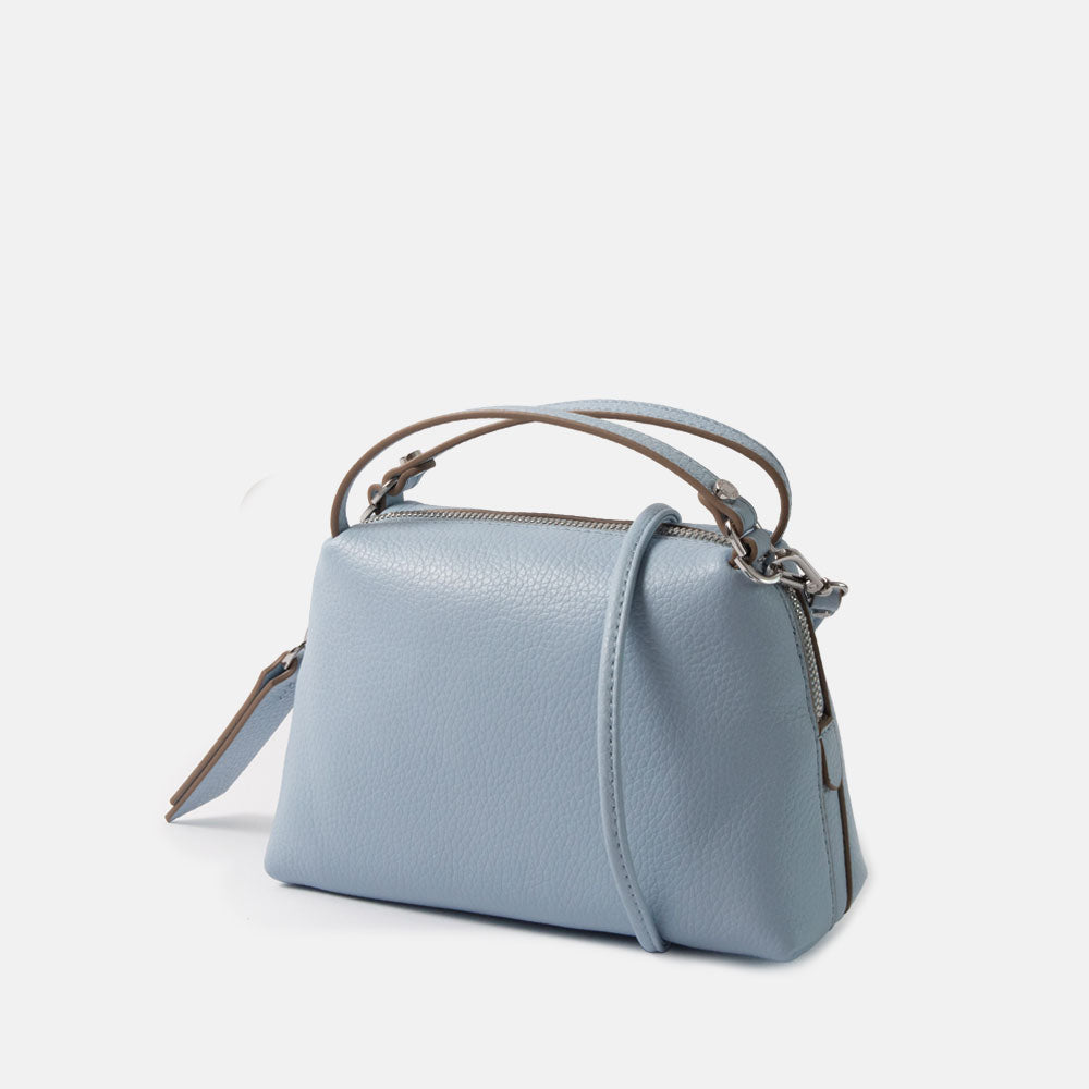 light blue leather small handbag with grab handles and removable crossbody strap on a white background