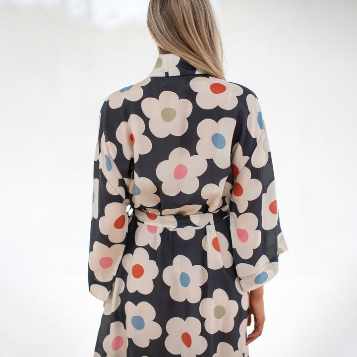 Woman wearing a floral patterned dressing gown with a white background
