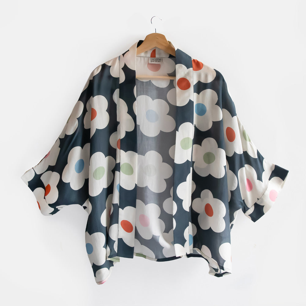 Floral patterned kimono on a hanger against a white background