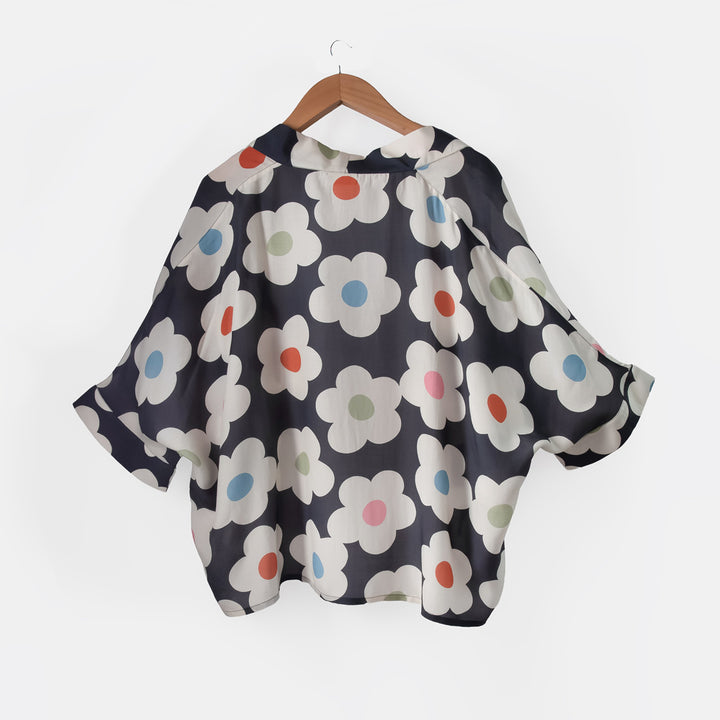 Floral patterned kimono on a hanger against a white background