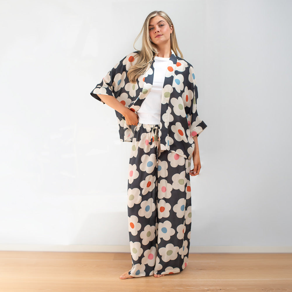 Woman wearing a floral kimono-style outfit on a plain background