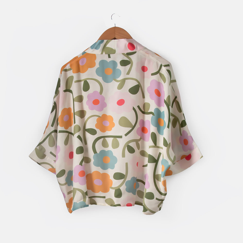 Floral patterned shawl on a wooden hanger against a white background