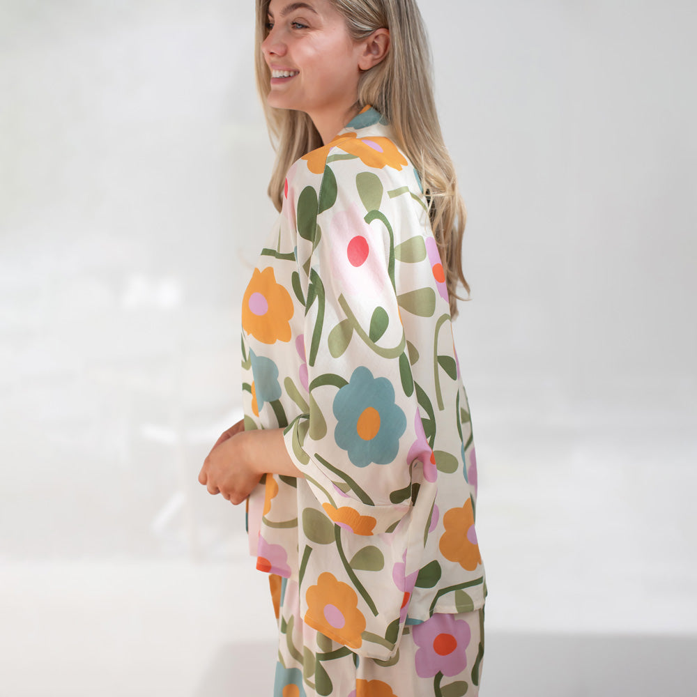 Woman wearing a floral patterned outfit on a white background