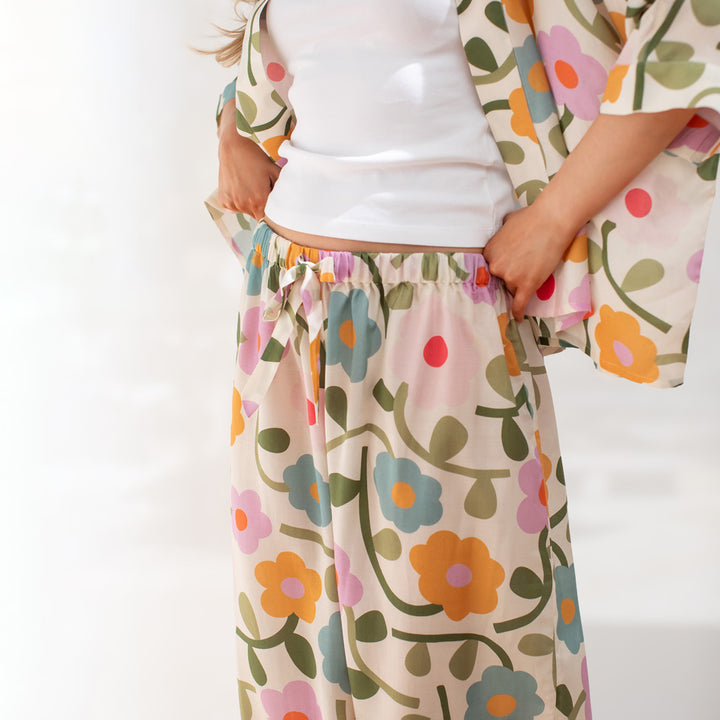 Person wearing a colorful floral pants with a plain background