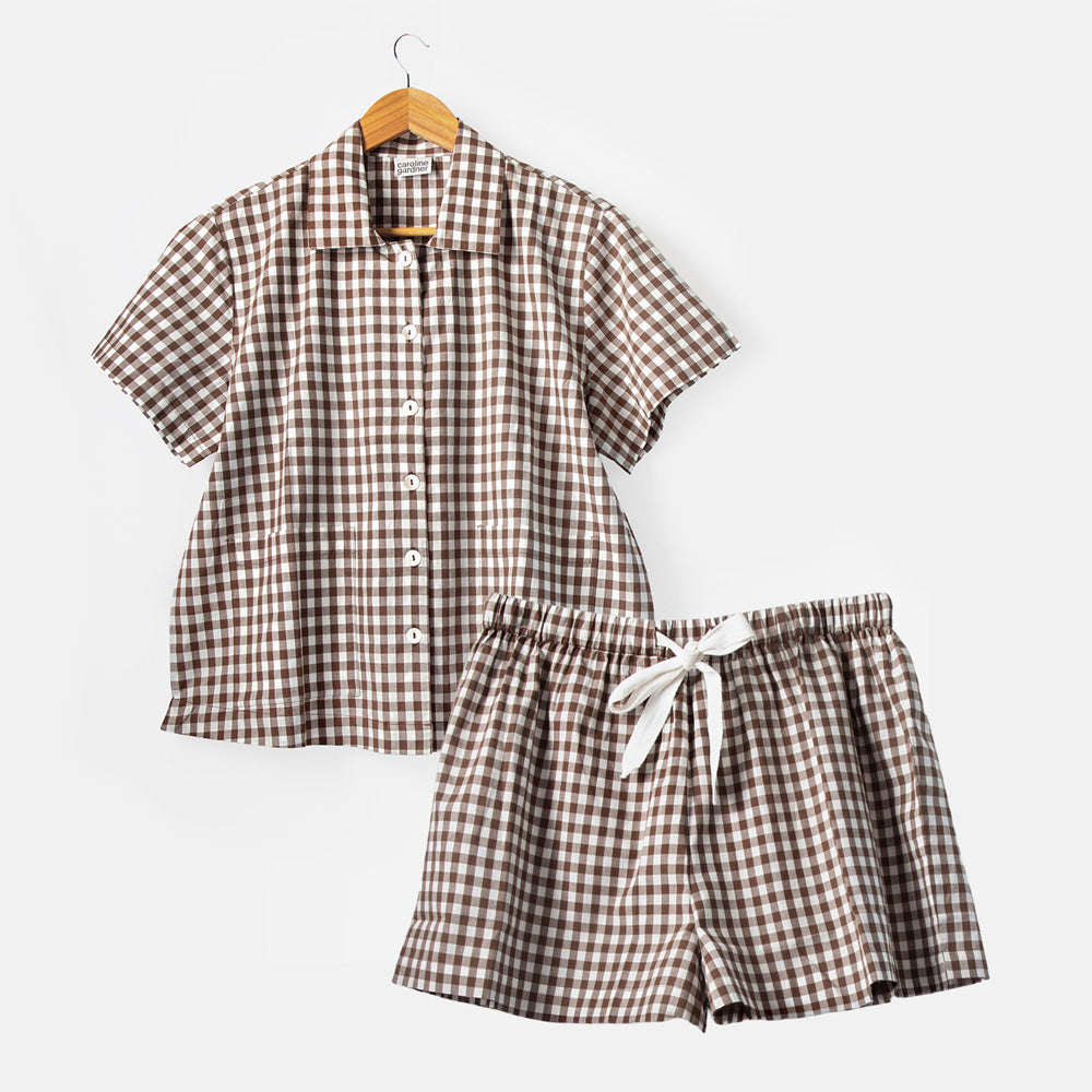 Brown and white checkered shirt and shorts set on a hanger against a white background