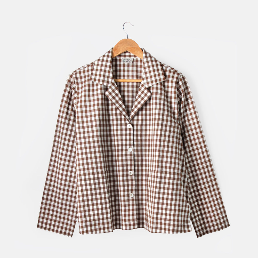 Brown and white checkered shirt on a hanger against a white background