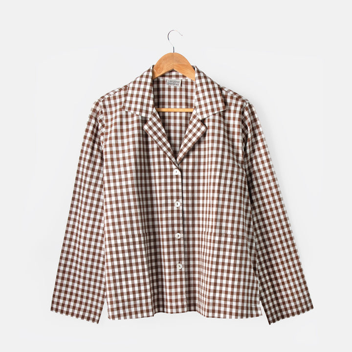 Brown and white checkered shirt on a hanger against a white background