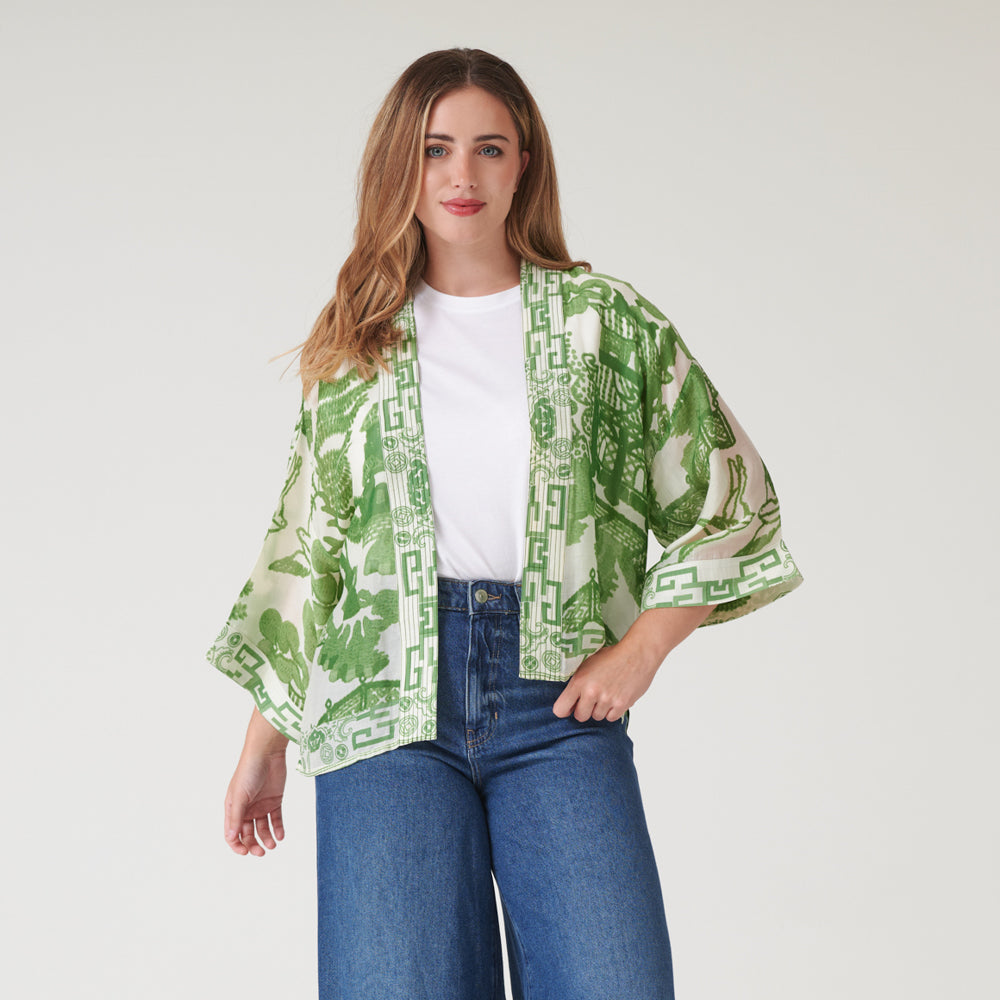woman wearing a green japanese style print short kimono with a white t-shirt and blue wash jeans