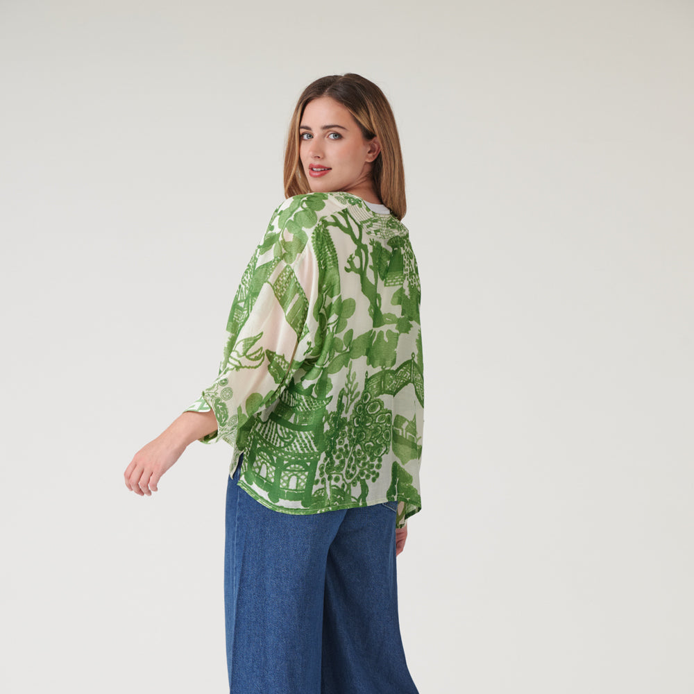 woman wearing a green japanese style print short kimono with blue wash jeans