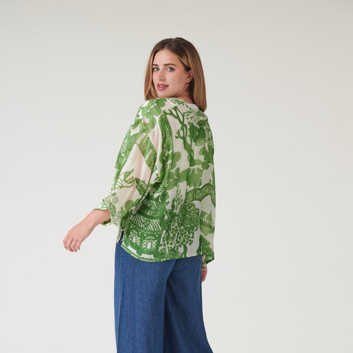 woman wearing a green japanese style print short kimono with blue wash jeans