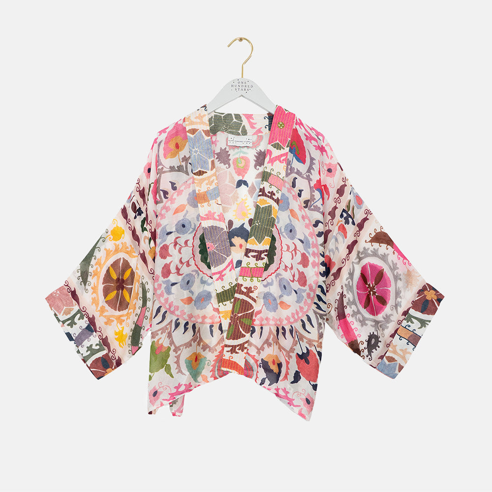 multi coloured patterned women's kimono on a coat hanger against a white background