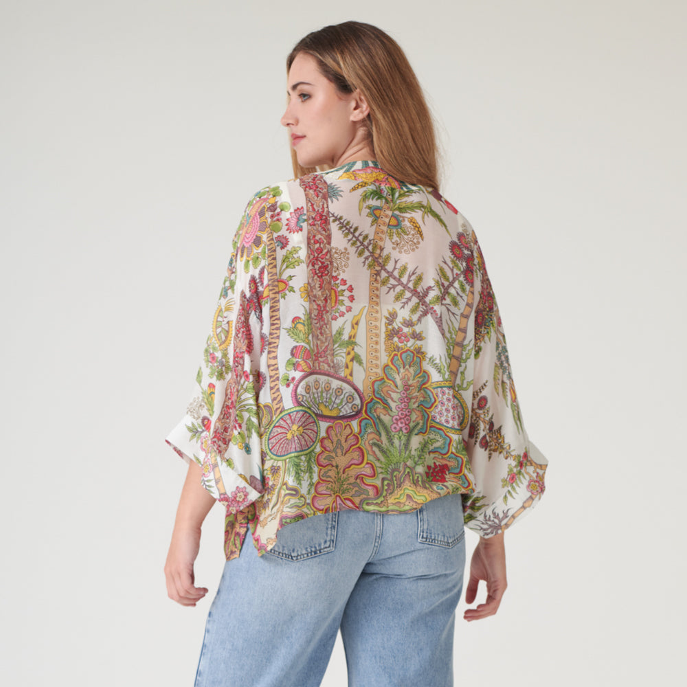 woman wearing a colourful floral print kimono with light wash jeans