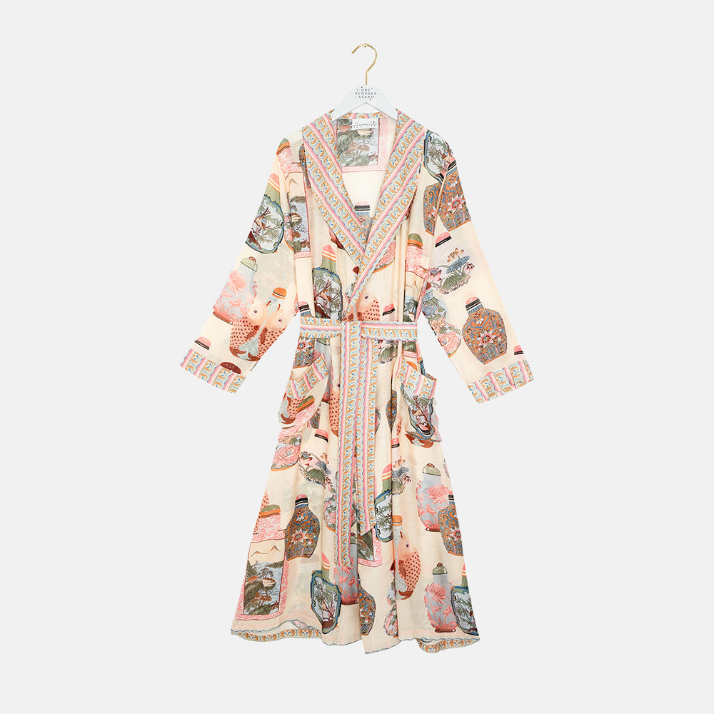 light pink dressing gown with perfume bottles print on a light grey background