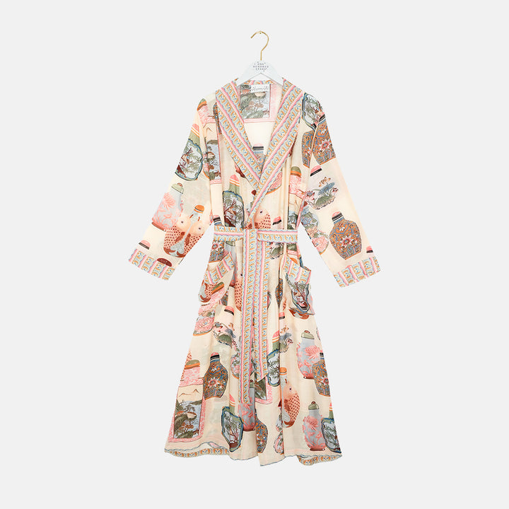 light pink dressing gown with perfume bottles print on a light grey background