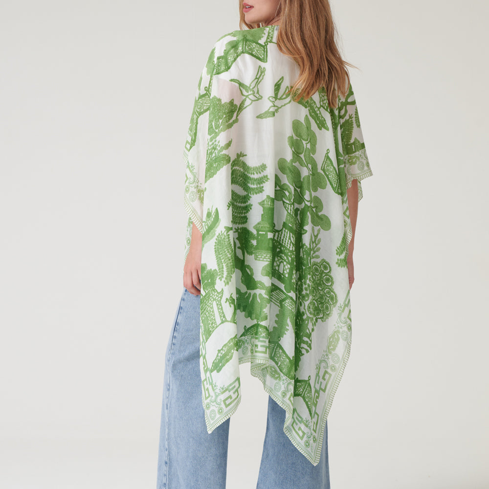 person wearing a green and white patterned throwover on a hanger against a white background