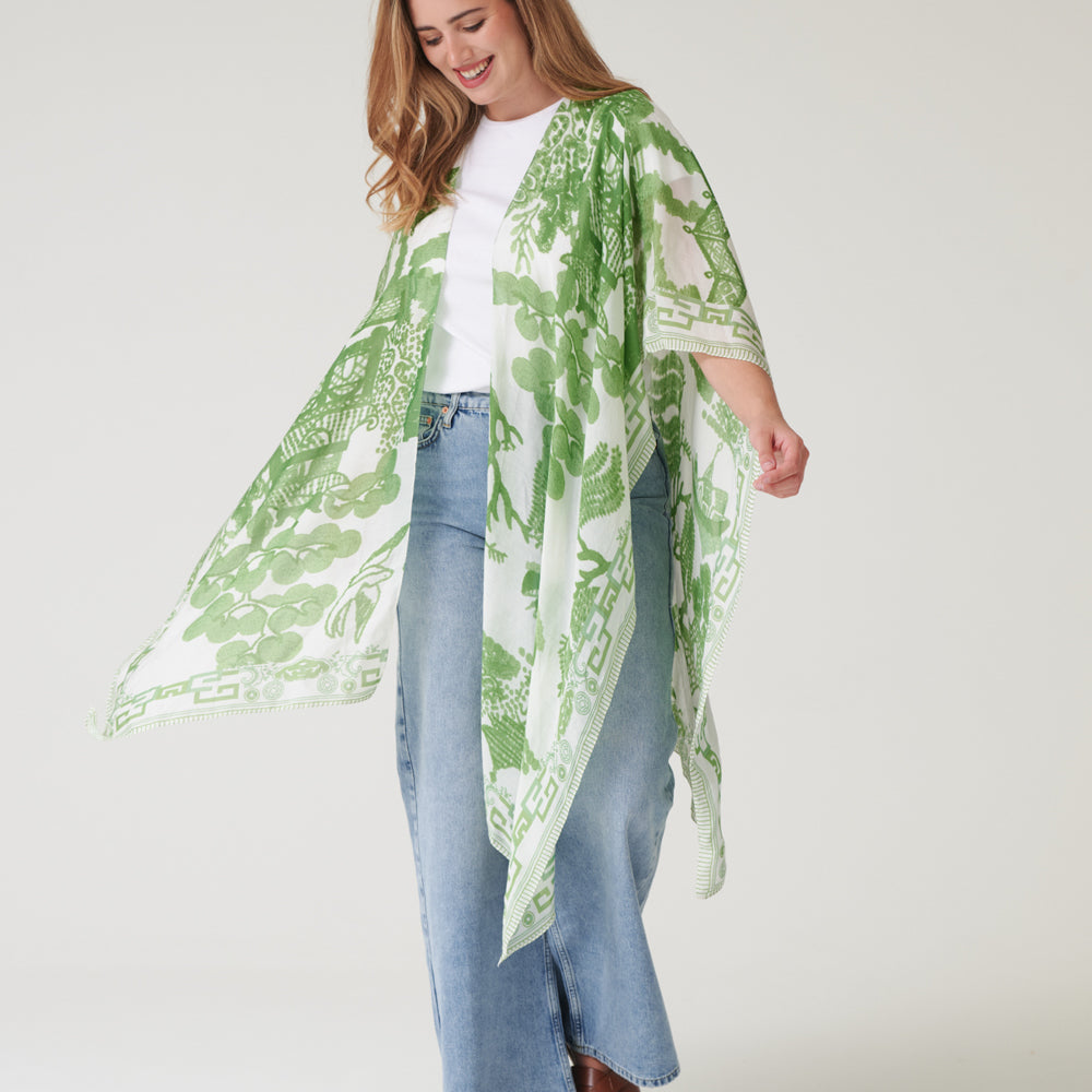 person wearing a green and white patterned throwover on a hanger against a white background