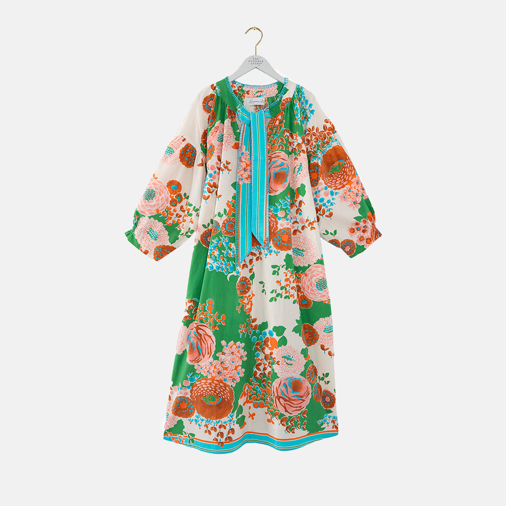 Colorful floral neck tie dress on a hanger against a white background