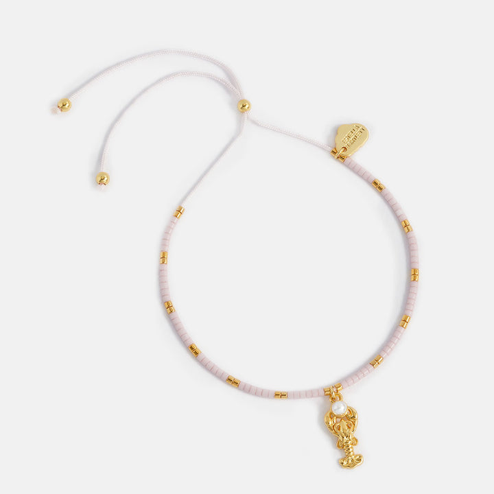 bracelet with pink & gold beads and a gold lobster charm