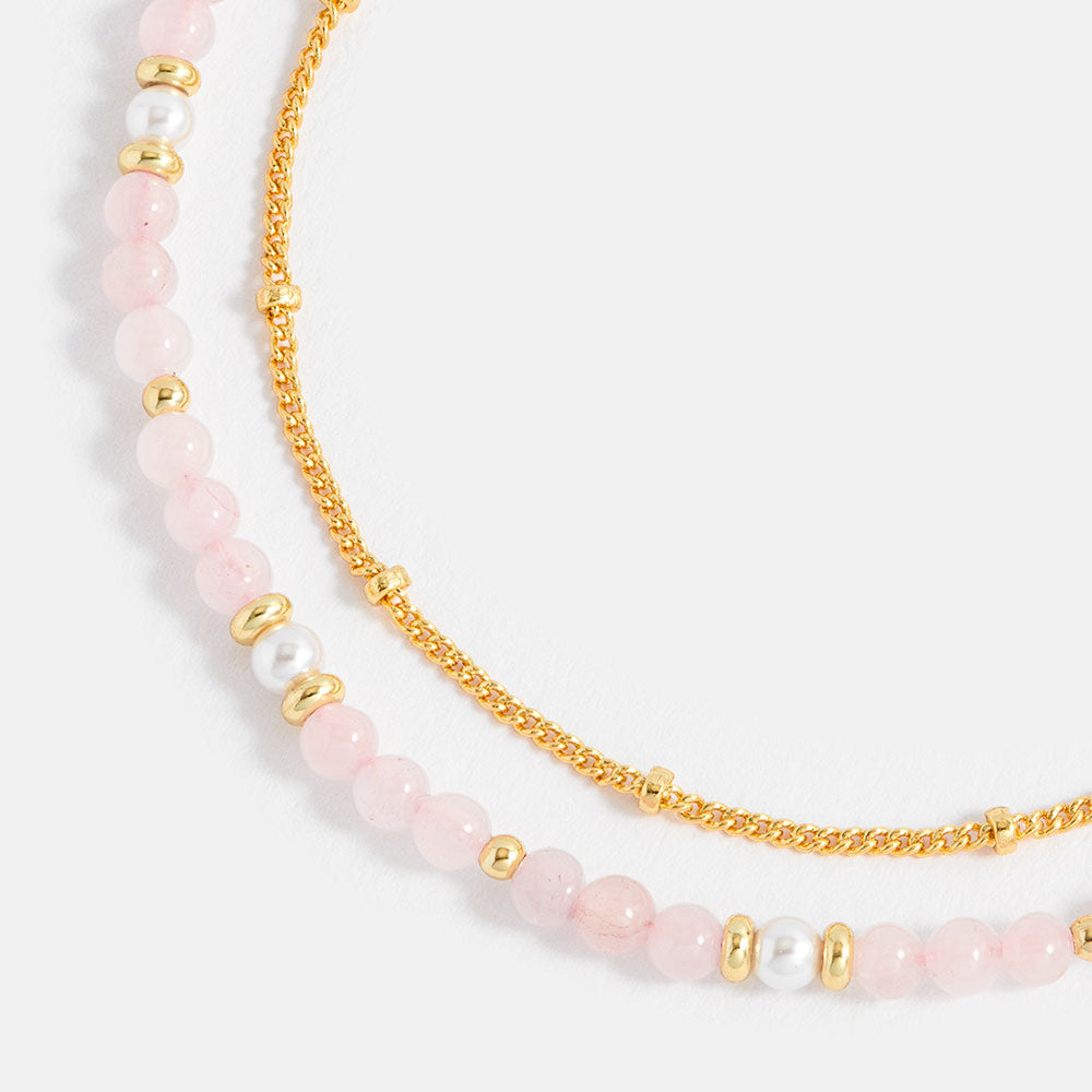 bracelet with pink beads and gold chain on a white background