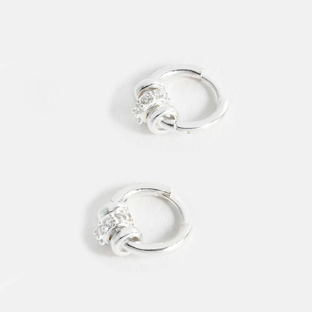 silver plated huggie hoop earrings with 3 silver discs, one with cubic zirconia