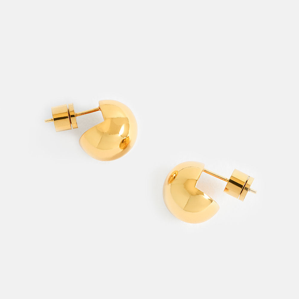 Gold sphere stud earrings on a light grey background