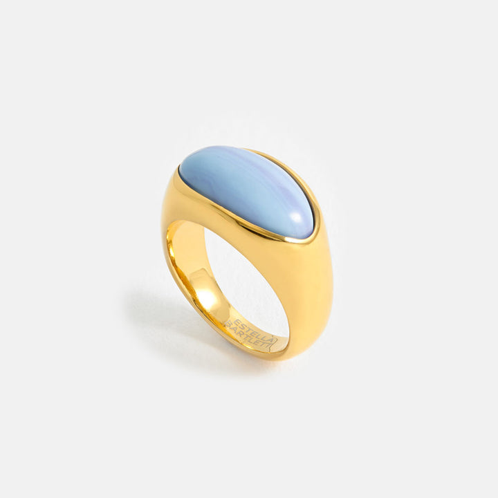 Gold ring with a light blue stone on a white background