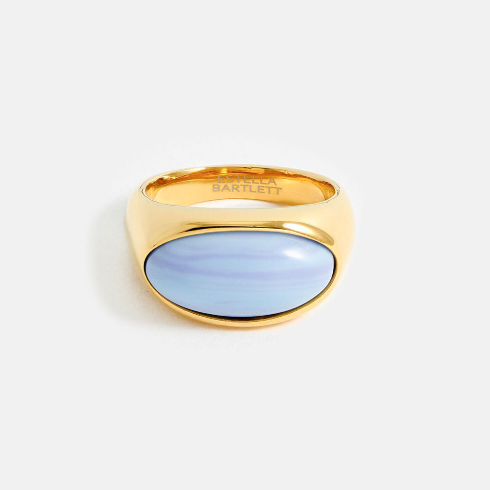 Gold ring with a light blue stone on a white background