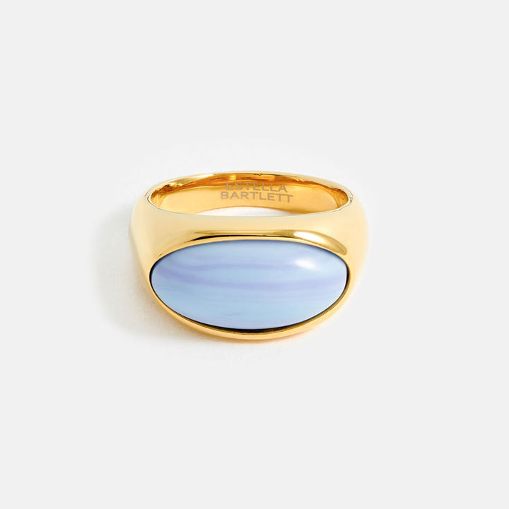 Gold ring with a light blue stone on a white background