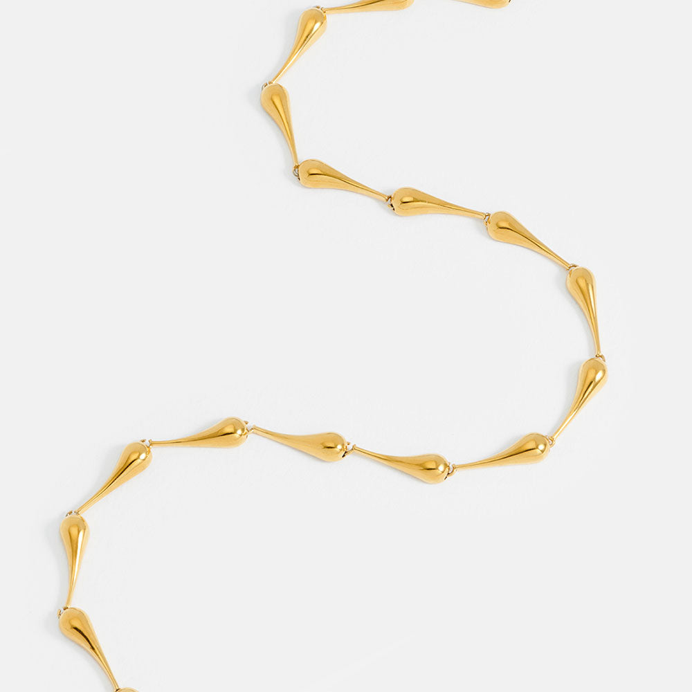 gold teardrop link necklace on a light grey background