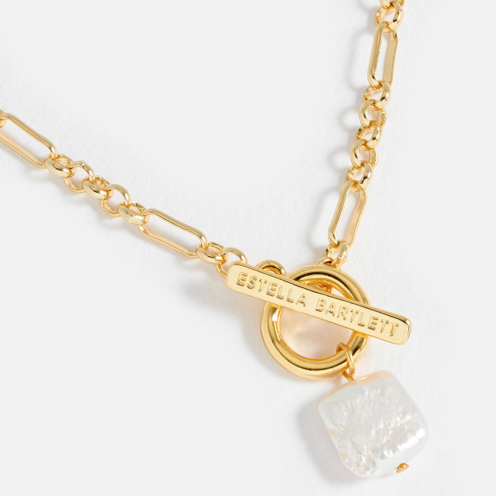 Gold chain necklace with a pearl pendant on a white background
