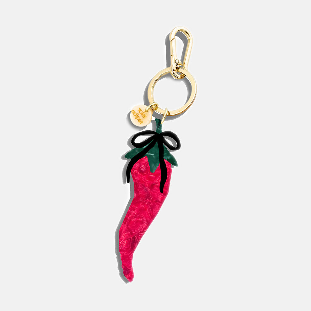 Bag charm with a red chili pepper design on a white background