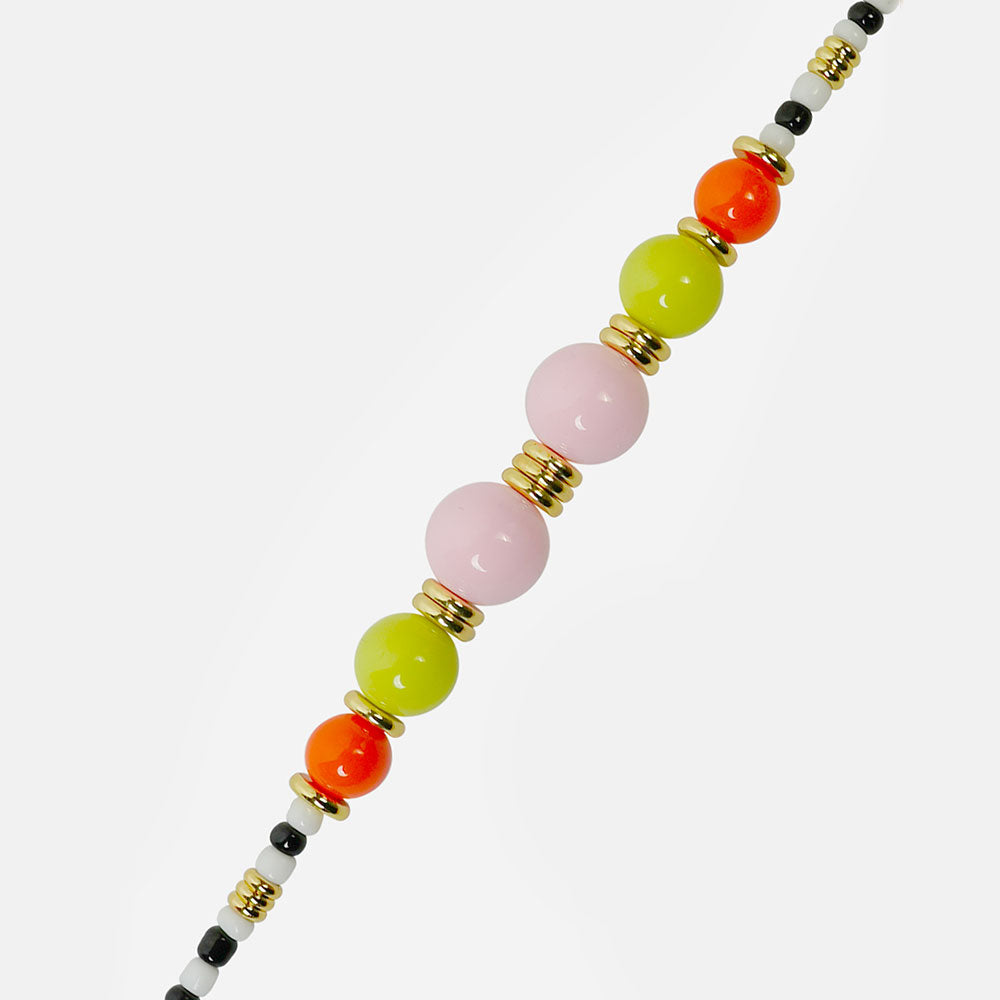 Phone chain with colourful beads and a gold charm on a light grey background