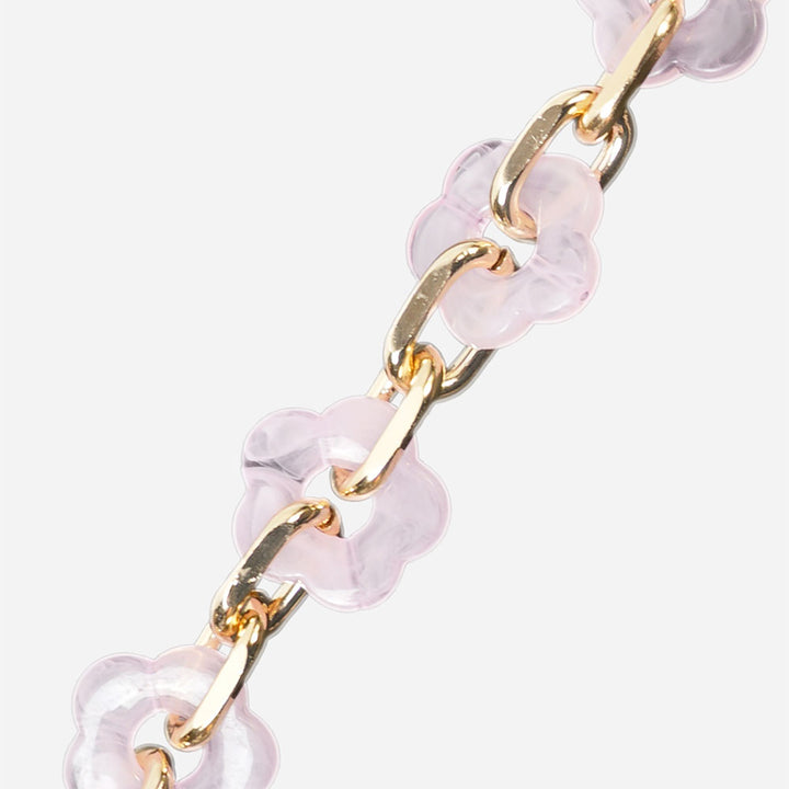Gold chain bracelet with pink flower beads on a white background