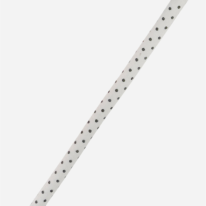 white & black polka dot vegan leather phone cord on a light grey background