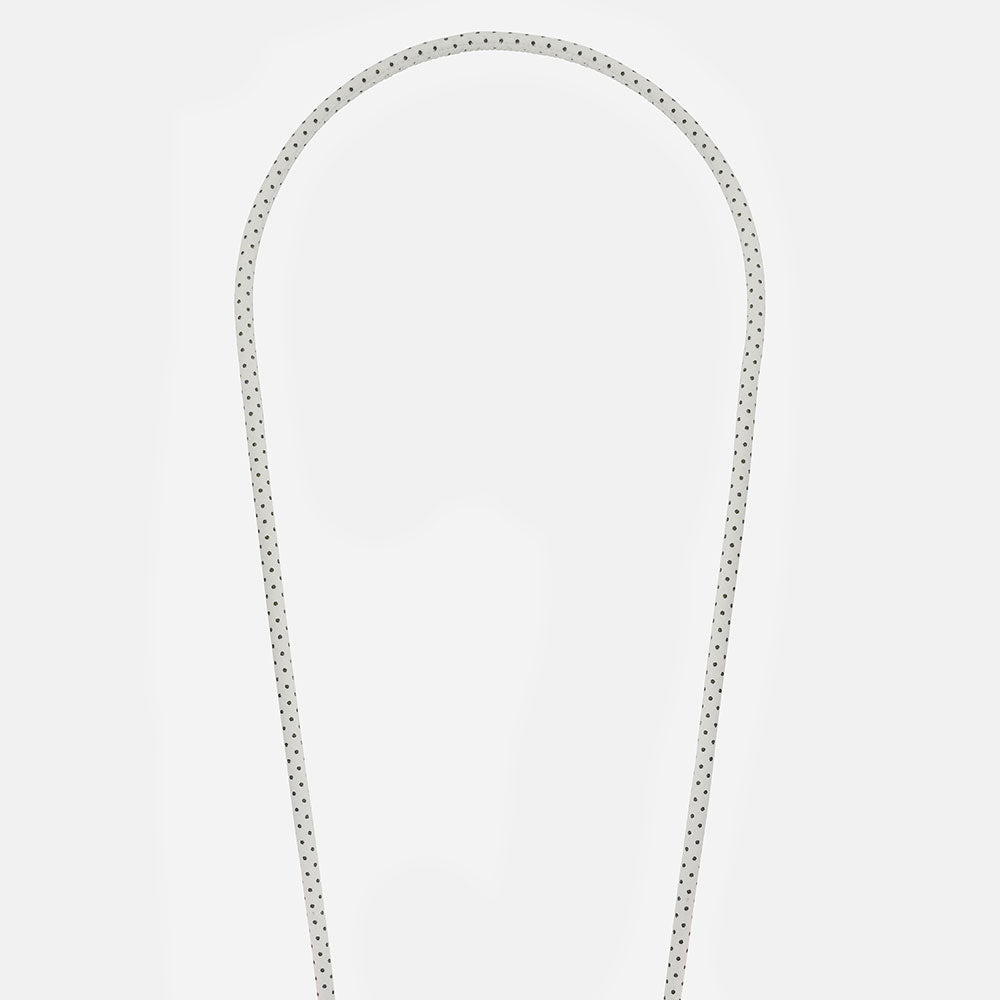 white & black polka dot vegan leather phone cord on a light grey background