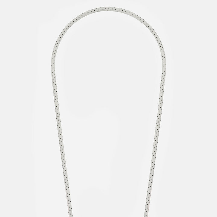 white & black polka dot vegan leather phone cord on a light grey background