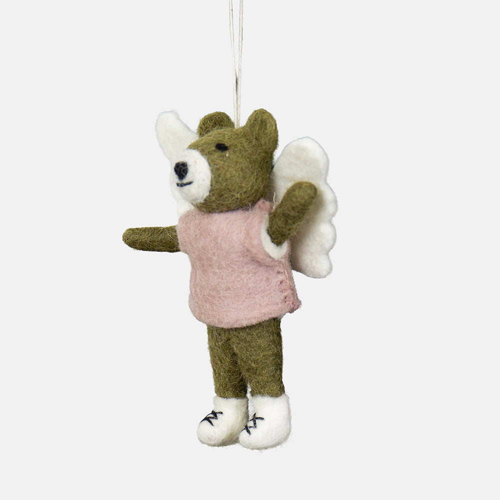 A felt bear hanging ornament wearing a pink top and white boots and with white angle wings, suspended by a thin white string against a light grey background.