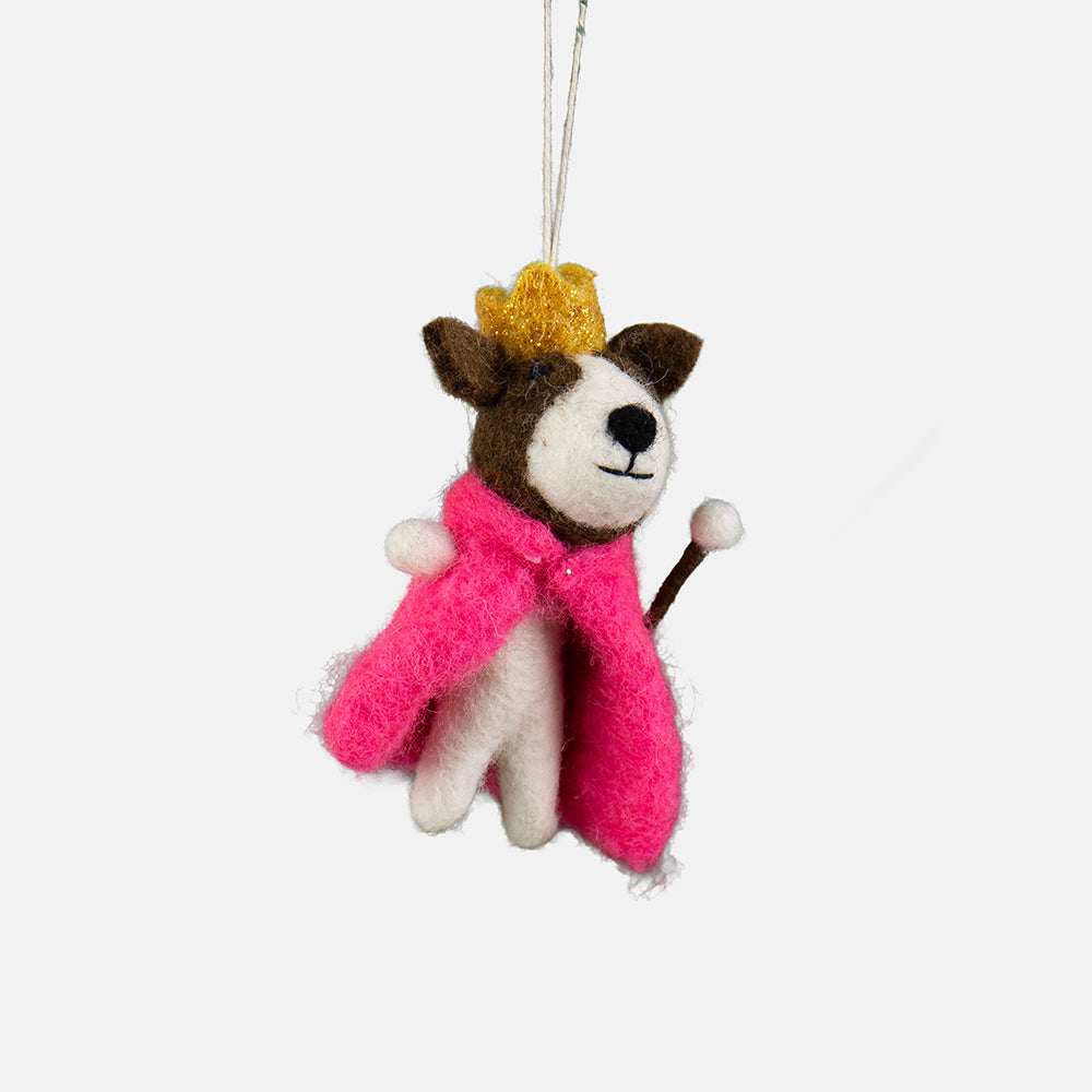A felt dog king hanging ornament wearing a pink cape and gold crown and holding a sceptre, suspended by a thin white string against a light grey background.
