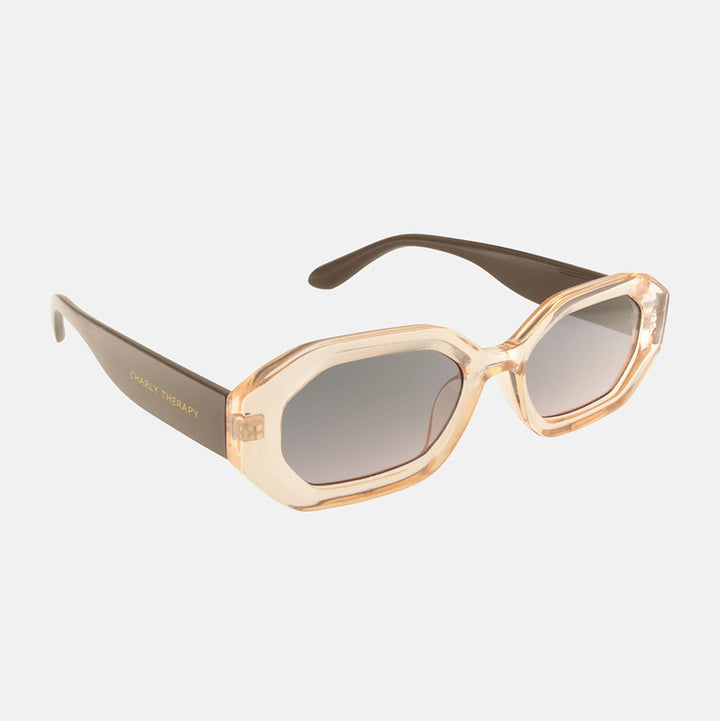 Sunglasses with a beige frame and grey gradient lenses on a white background