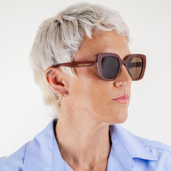Person wearing sunglasses with a neutral background