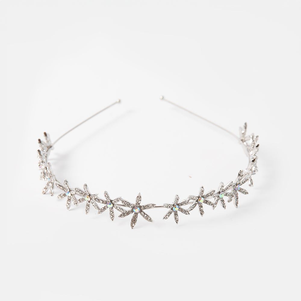 Silver headband with flower-like designs on a white background