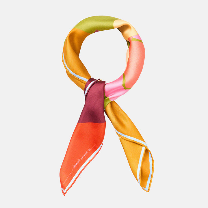 colourful silk scarf tied in a loop shape with red, purple, orange, yellow green and gold colours