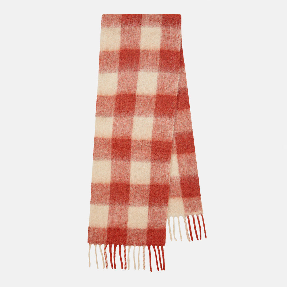A brushed orange and cream check scarf with fringed ends hanging against a light grey background.