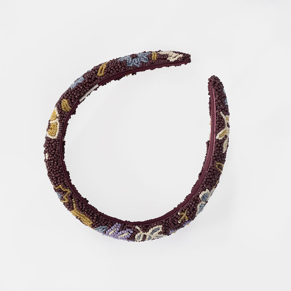 A wide, padded headband featuring a multicolor beaded floral pattern over a deep burgundy base, shown against a plain white background.