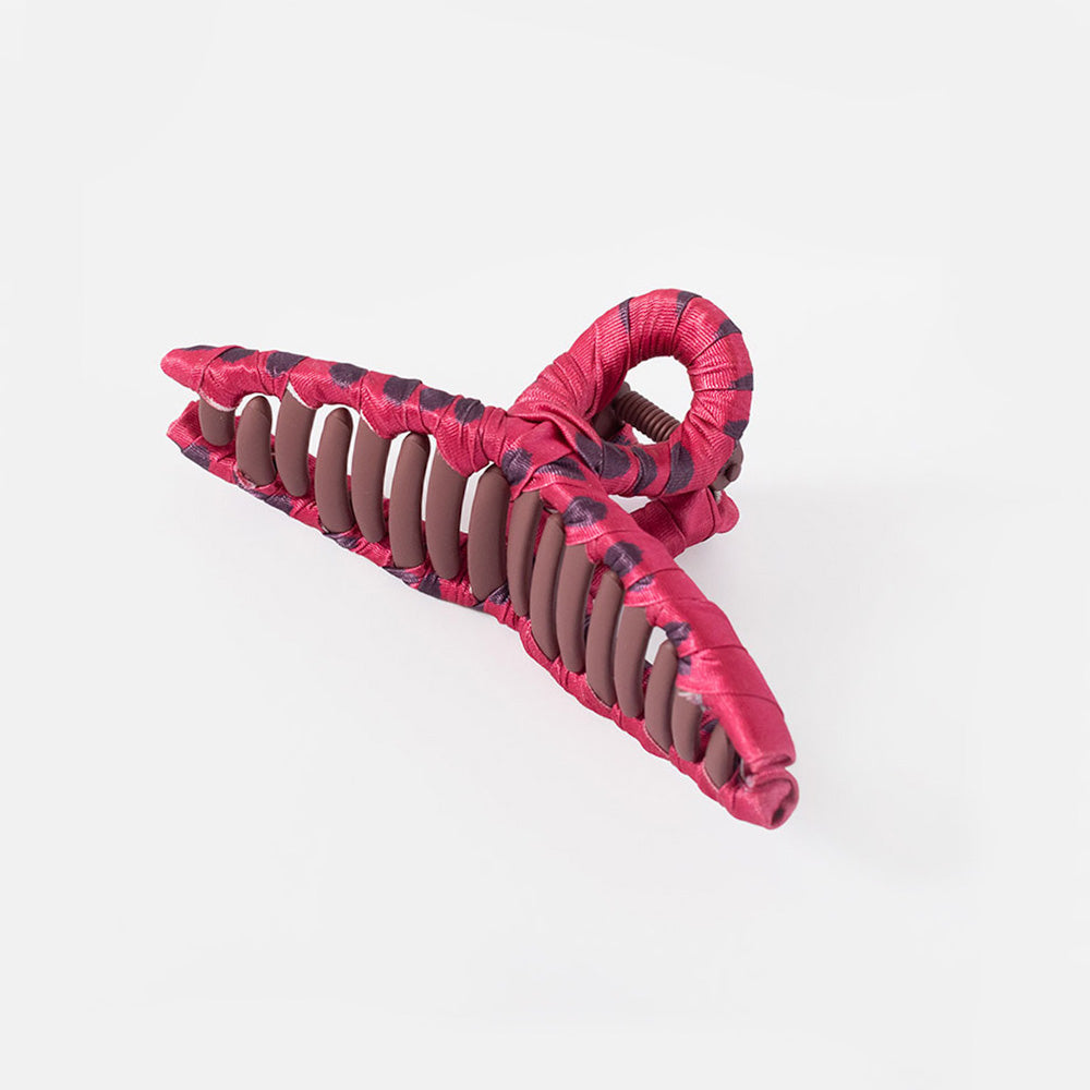 A large cotton claw hair clip in a glossy pink color, shown on a grey background.