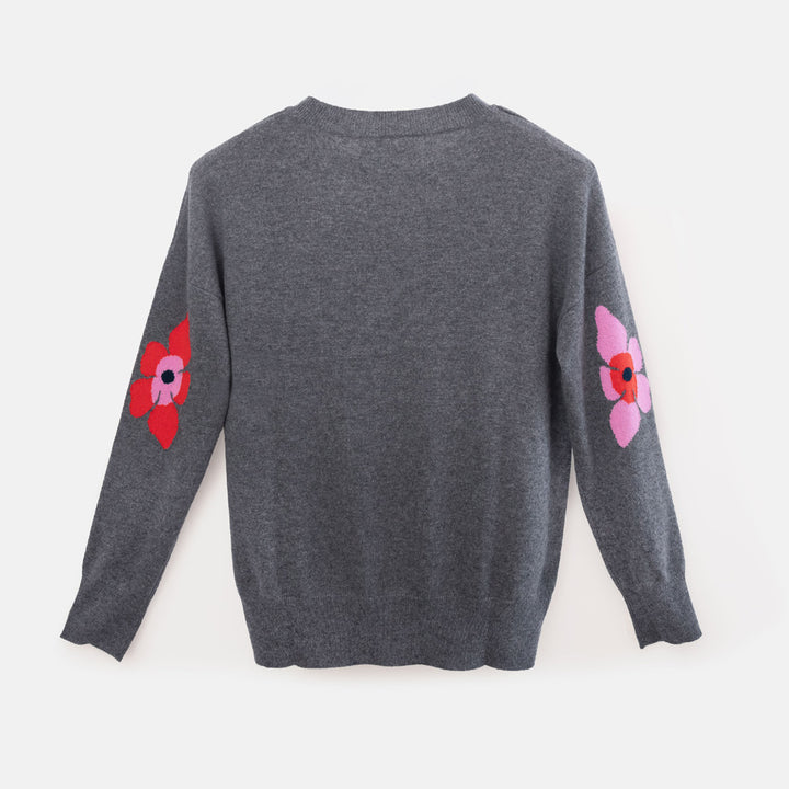 A dark gray long-sleeve knit sweater shown from the back, featuring two colorful floral patches on the sleeves.