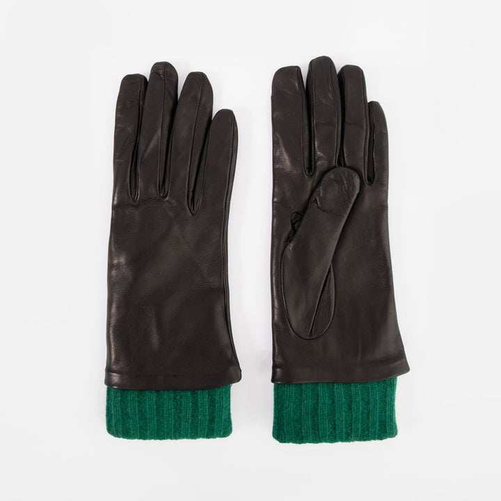 A pair of black leather gloves with a contrasting green ribbed knit cuff, displayed flat against a light gray background.