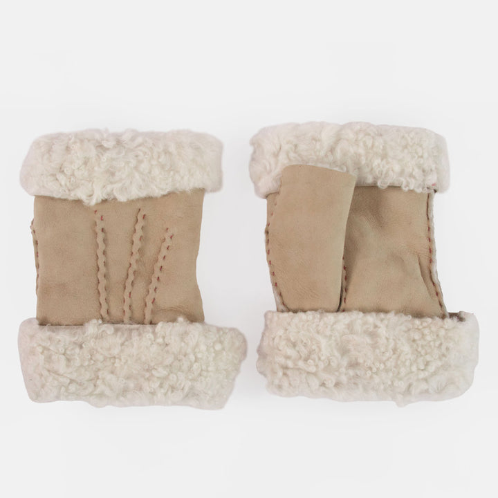A pair of beige shearling wrist warmers with thick cream-colored shearling lining, shown from a top-down view on a plain white background.