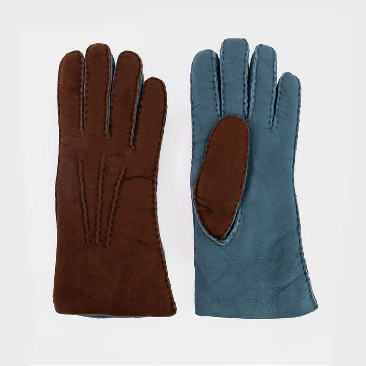 A pair of leather gloves shown flat against a light gray background. The left glove is solid dark brown, and the right glove is a muted blue-gray with a contrasting brown palm patch.