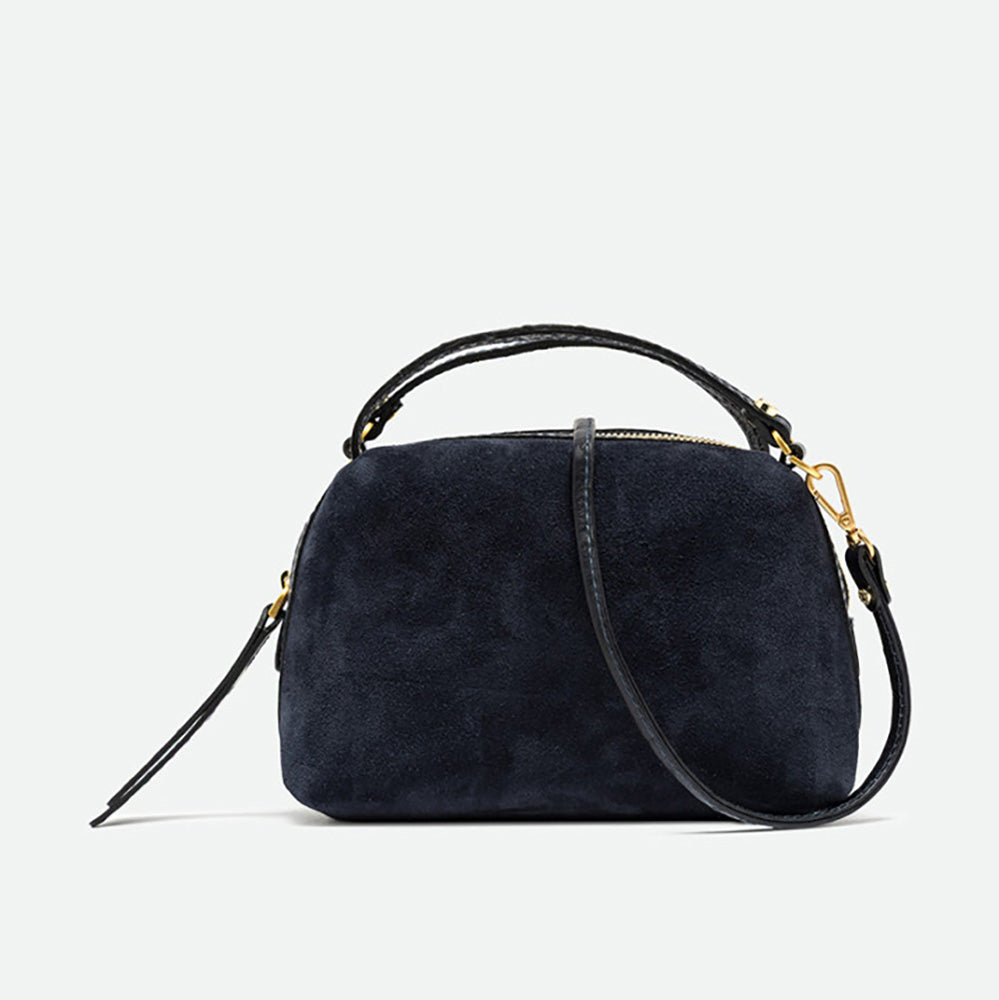 Small navy suede handbag with black leather top handles, crossbody strap and gold hardware